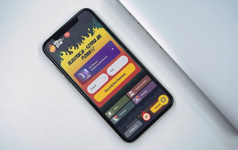 Osoba trzymająca iPhone'a z Hellspin Kasyno